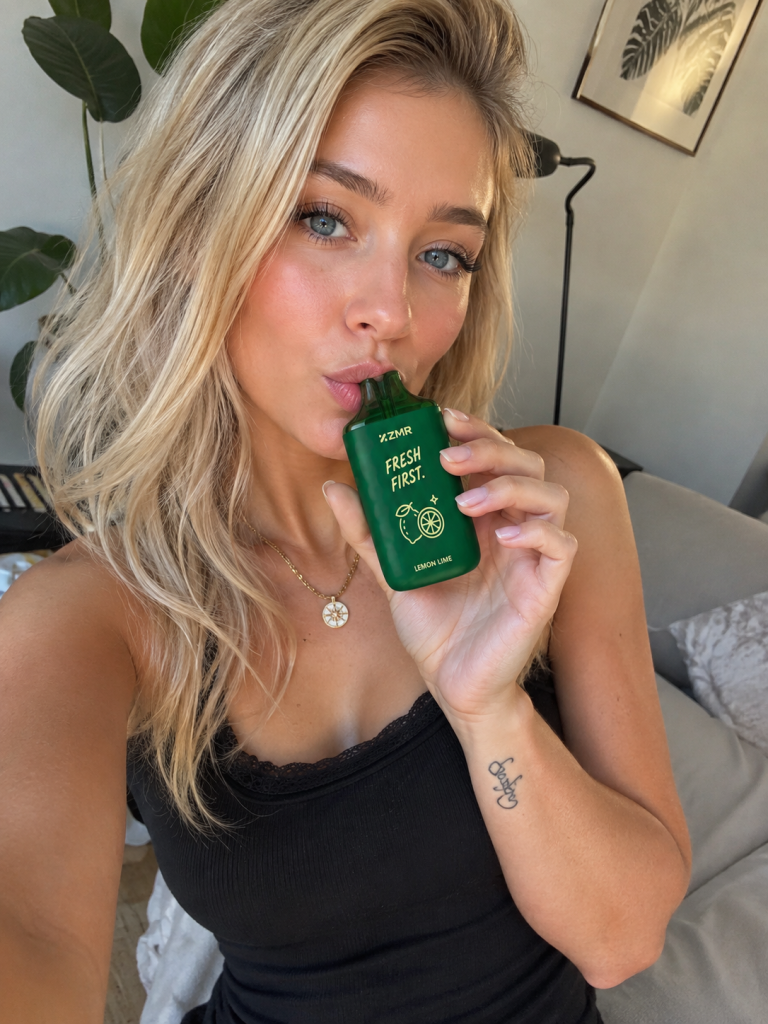 Woman using a ZMR Fresh Pineapple vape device